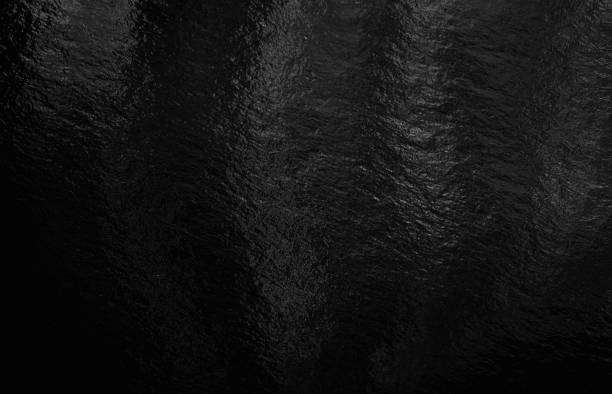 istock Black foil background with highlights and uneven texture 1286358089