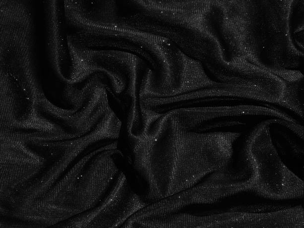 istock Shiny black crumpled fabric texture. Elegant cloth background 1286358137