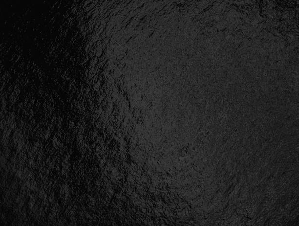 istock Black foil background with highlights and uneven texture 1286358177