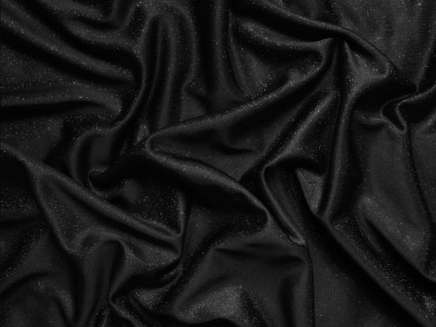 istock Shiny black crumpled fabric texture. Elegant cloth background 1286358188