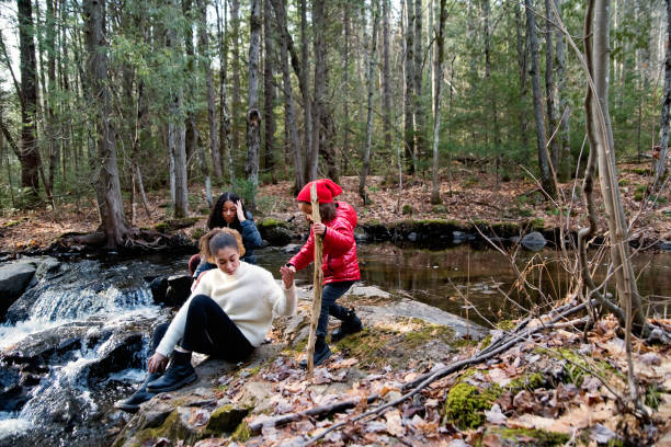 istock Mixed-race sisters relaxing on river side in autumn nature. 1286358206