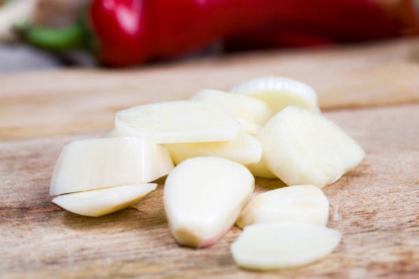 cloves of ripe garlic cloves of ripe garlic on the kitchen table while cooking a dish with garlic, sliced garlic on a cutting Board that is added to the food to give a pleasant taste Relish stock pictures, royalty-free photos & images