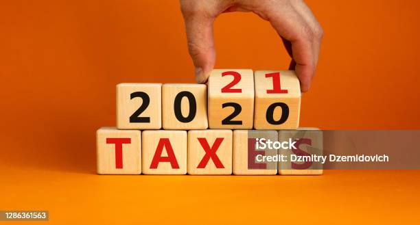 Business Concept Of Planning 2021 Male Hand Flips Wooden Cubes And Changes The Inscription Taxes 2020 To Taxes 2021 Beautiful Orange Background Copy Space Stock Photo - Download Image Now