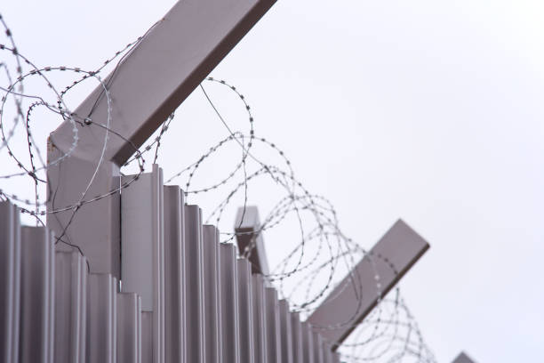 istock Fence with metal mesh on a background of blue sky 1286364143