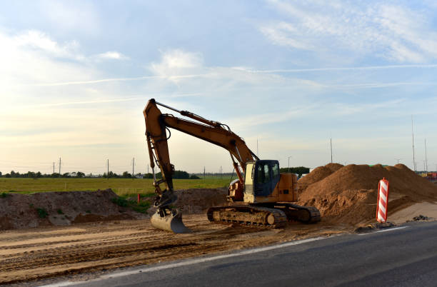 Excavator On Earthworks and Road Construction in City. Temporary Traffic Regulation from carrying out road works or activity on the public highway. Roadway Work Zone Safety. Out of focus, motion blur