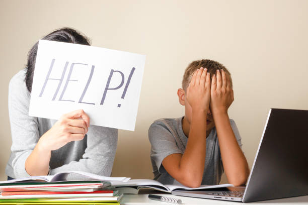 istock Learning difficulties, remote education, online learning and working at home. Tired mother and sad kid need help to do homework 1286366057