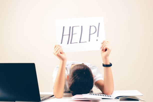istock Learning difficulties, school, education, online remote learning concept. Sad kid with laptop computer holding card with Help word 1286366613