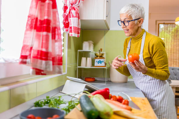 istock Senior woman cooking and using tablet. 1286368188