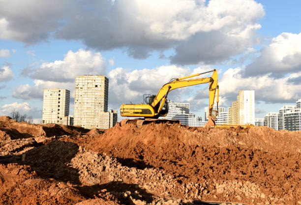 istock Excavator during earthmoving at construction site. Backhoe dig ground for the construction of foundation and laying sewer pipes district heating. 1286368560