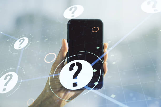 istock Creative abstract question mark hologram and hand with mobile phone on background, future technology concept. Multi exposure 1286369731