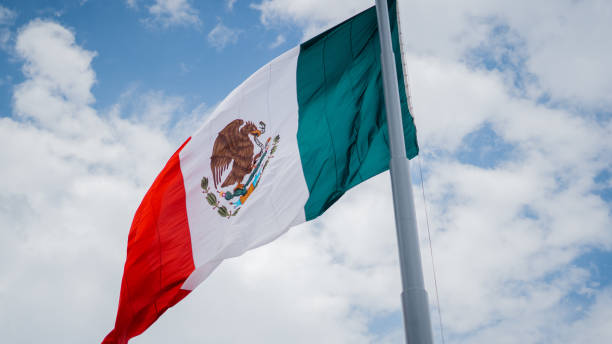 istock Mexican Flag Waving in the Wind Under a Blue Sky 1286373211