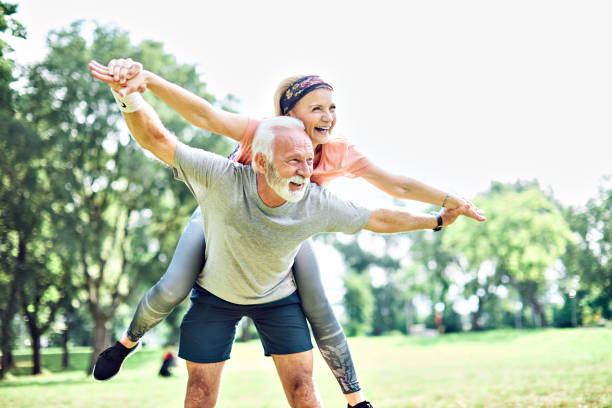 outdoor senior fitness kobieta mężczyzna styl życia aktywny sport ćwiczenia zdrowe dopasowanie emerytury miłość zabawa piggyback - senior couple zdjęcia i obrazy z banku zdjęć