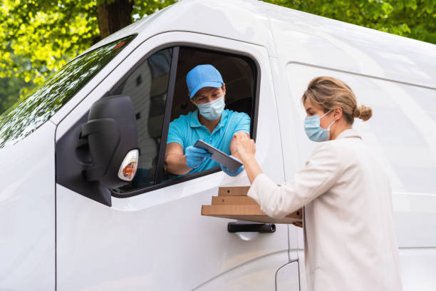 istock Safe delivery - courier on a van brings a pizza to the client 1286375951