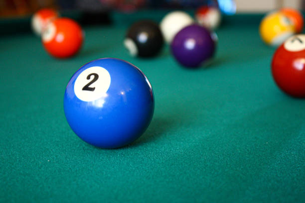 Close-up of the 2 ball from a pool table. Other balls can be seen in the background.