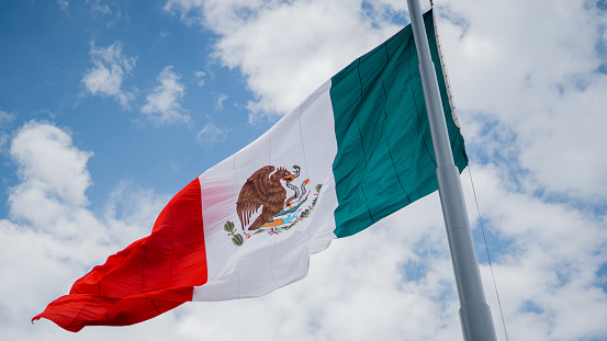 Man walking while holding a mexican flag in the street
