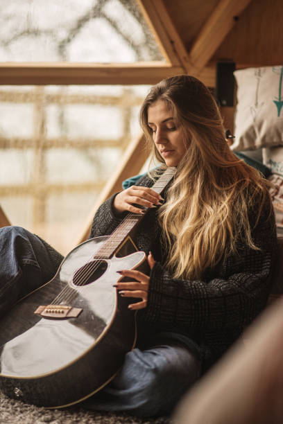 istock Young woman with a guitar inside a wooden dome 1286377384