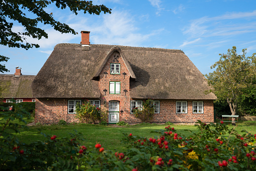 NEBEL, GERMANY - SEPTEMBER 29, 2020: Panoramic image of a traditional Frisian house against blue sky on September 29, 2020 on Amrum, Germany