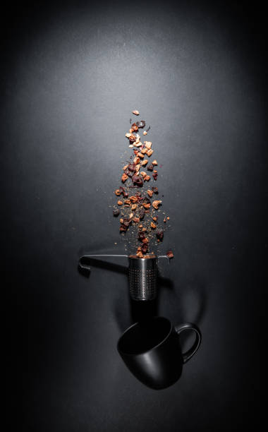 Composition of fruit tea cup and infuser - strainer. Flat lay isolated on gray black background. Copy space