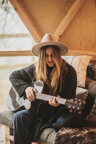 istock Young woman playing the guitar inside a wooden dome 1286378316