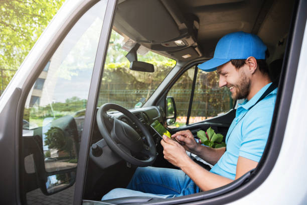 Young delivery man in a van is checking packages and waybill using tablet pc Young courier man in a van is checking packages and waybill using tablet pc before delivery service vehicle stock pictures, royalty-free photos & images