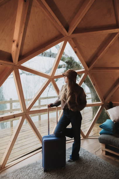 istock Young tourist with suitcase inside a wooden dome in a forest 1286381753