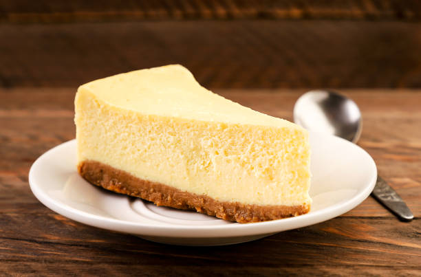 istock Cheesecake piece on a plate on a wooden background 1286382052