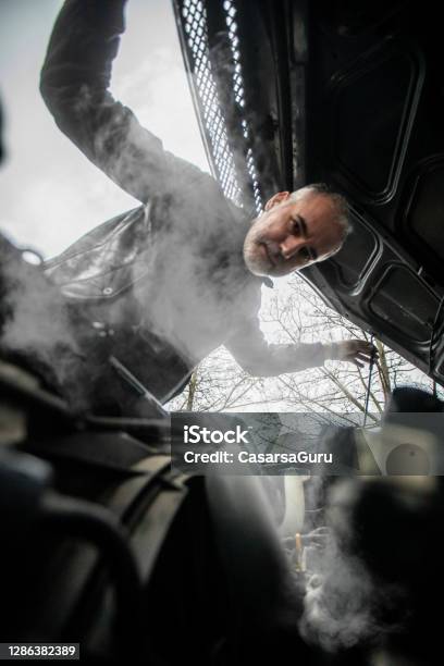 Steam Coming Out Of Car Engine While Mature Man Is Opening The