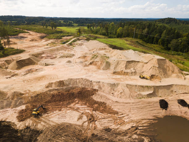 istock Top drone view. Excavators work on a sand pit. Extraction of sand. Heavy equipment earthmoving. Summer landscape. Green forest. 1286382436