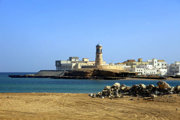 a cidade de sur no mar e o farol de al ayjah, na entrada do porto, ambos vistos da praia, omã - oman town arabia arabian peninsula - fotografias e filmes do acervo