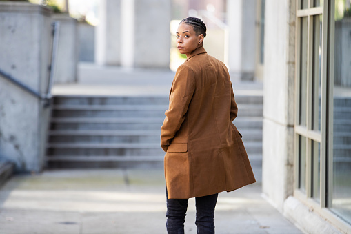 Young black woman looking back over her shoulder while walking