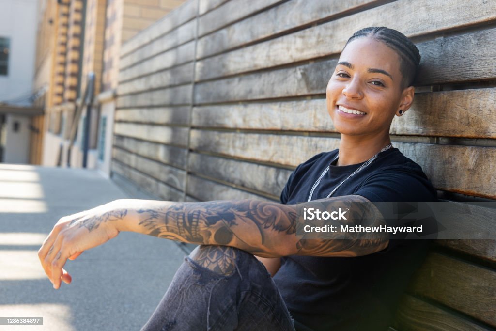 Pretty African American Black Woman Sitting And Smiling Outside With Tattoos On Her Arm Stock Photo - Download Image Now - iStock Pretty African American Black Woman Sitting And Smiling Outside With Tattoos On Her Arm Stock Photo - Download Image Now - iStock