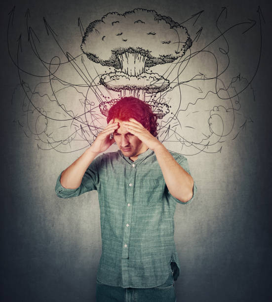 Bewildered man head explosion concept. Guy suffering headache, hands to forehead, looking down depressed. People mental health concept. Stress causes migraine and anxiety problems, dementia disease. concepto de explosión de cabeza de hombre desconcertado. un tipo sufriendo dolor de cabeza, de las manos a la frente, mirando deprimido. concepto de salud mental de las personas. el estrés causa problemas de migraña y ansiedad, demencia.