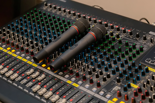 Microphone placed on the sound mixer with botton sound adjust. Sound and microphone tuner in the control room.