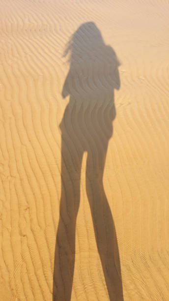 istock Woman shadow on the sand 1286386466