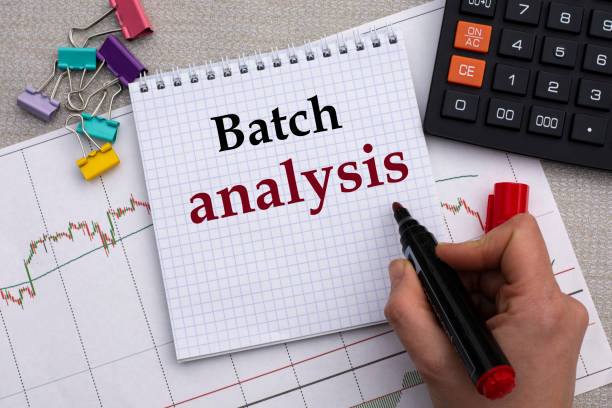 istock A woman's hand writes in a notebook the words BATCH ANALYSIS on the background of a graph, calculator 1286387692