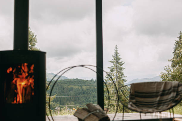 istock Beautiful view on mountains hills and trees through window cabin with fireplace 1286388928