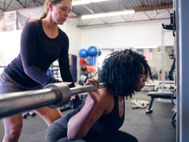 istock Woman Working with a Trainer in a Gym 1286391919