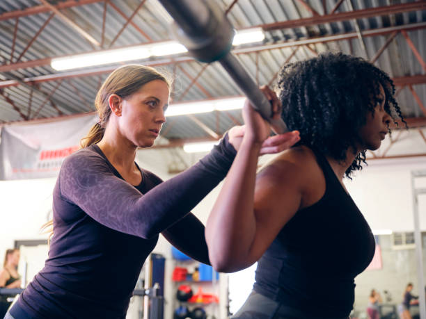 istock Woman Working with a Trainer in a Gym 1286392006