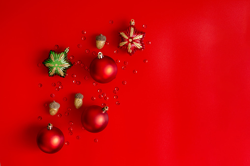 Christmas composition: red, gold and green decorations on a red background. Flat lay, top view, copy space