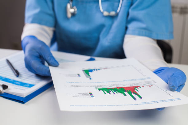 Doctor wearing protective gloves holding document chart