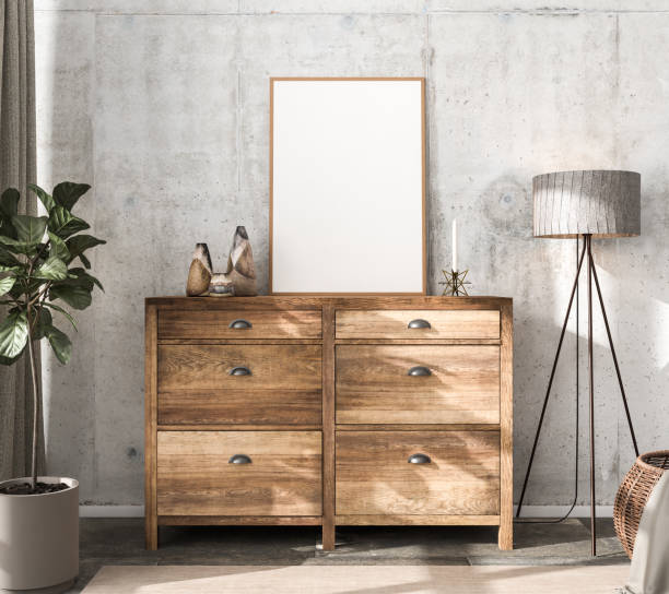 istock Interior scene mockup: wooden sideboard with an empty picture frame, vases and a candle on top. Floor lamp and fig tree, curtain and rattan basket with blanket to the sides. Concrete wall. 3d render mockup. 1286395577