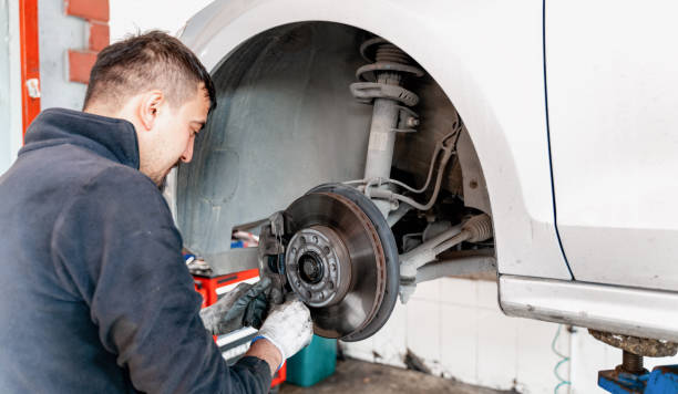 istock Car mechanic hands replace brakes in garage 1286398791