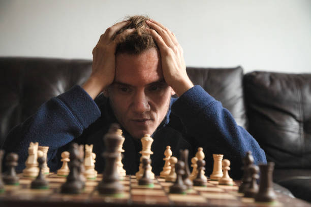 istock Close-up on pensive trans autistic male over a chess board head in hands 1286399209