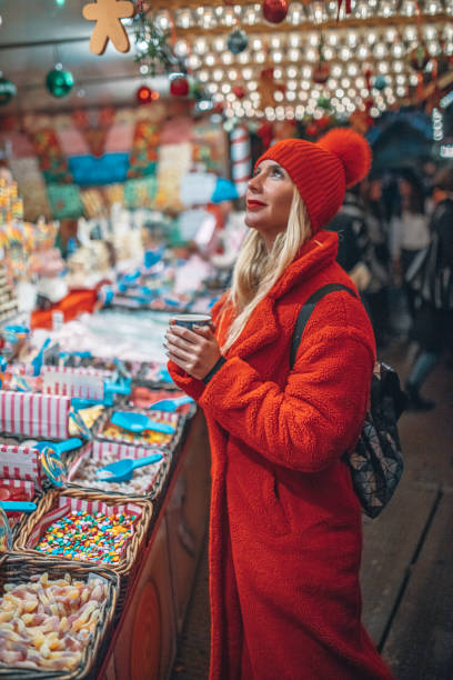 クリスマスマーケットで買い物をする若い女性 - ウィンターワンダーランド ストックフォトと画像