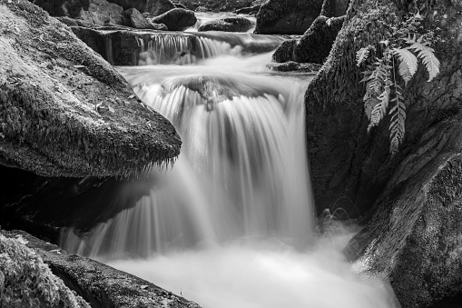 Its a water fall flowing through rocks.The black and white image and shape of image lile a water from is a symbolic abstract.