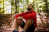 istock Portrait of relaxed young man with bluetooth headphones in forest 1286401346