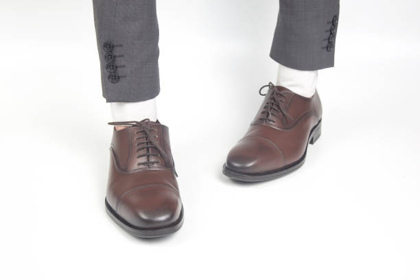 istock Classic brown leather shoes worn on the hands on a white background 1286401605