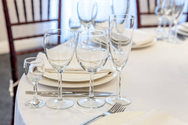 istock Fancy table set for dinner with napkin glasses in restaurant, luxury interior background. Wedding elegant banquet decoration and items for food arranged by catering service on white tablecloth table 1286405254