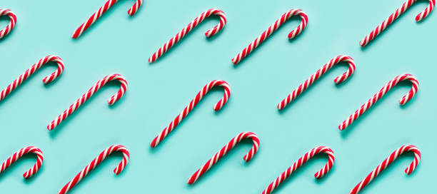 istock Christmas candy cane lied evenly in row on blue background. Flat lay and top view 1286407508