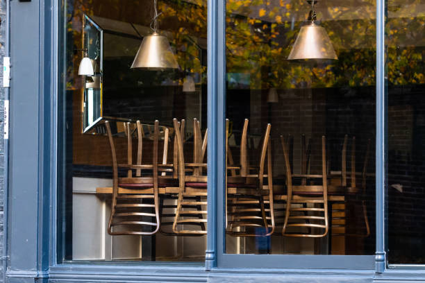 Window of an empty restaurant forced to close amid COVID-19 pandemic Chairs on the tables of a restaurant forced to close during lockdown to control COVID-19 pandemic, Cambridge, UK close stock pictures, royalty-free photos & images